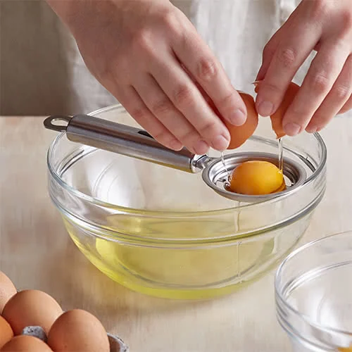 Using an Egg Separator Tool in How to Separate Egg Whites Without Breaking the Yolk